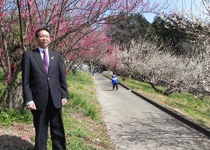 梅の花と区長の写真