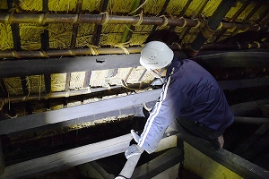 屋根裏で縄を受け取る様子