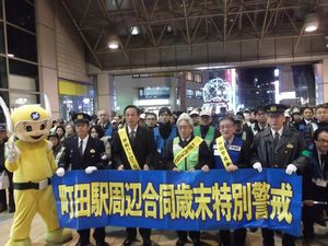 横断幕を持って歳末特別警戒を呼び掛けている写真