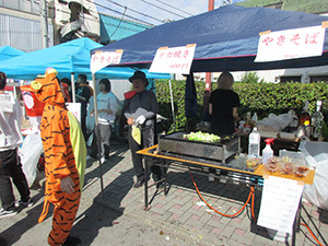 イカ焼き屋台の前にいる南区長　写真